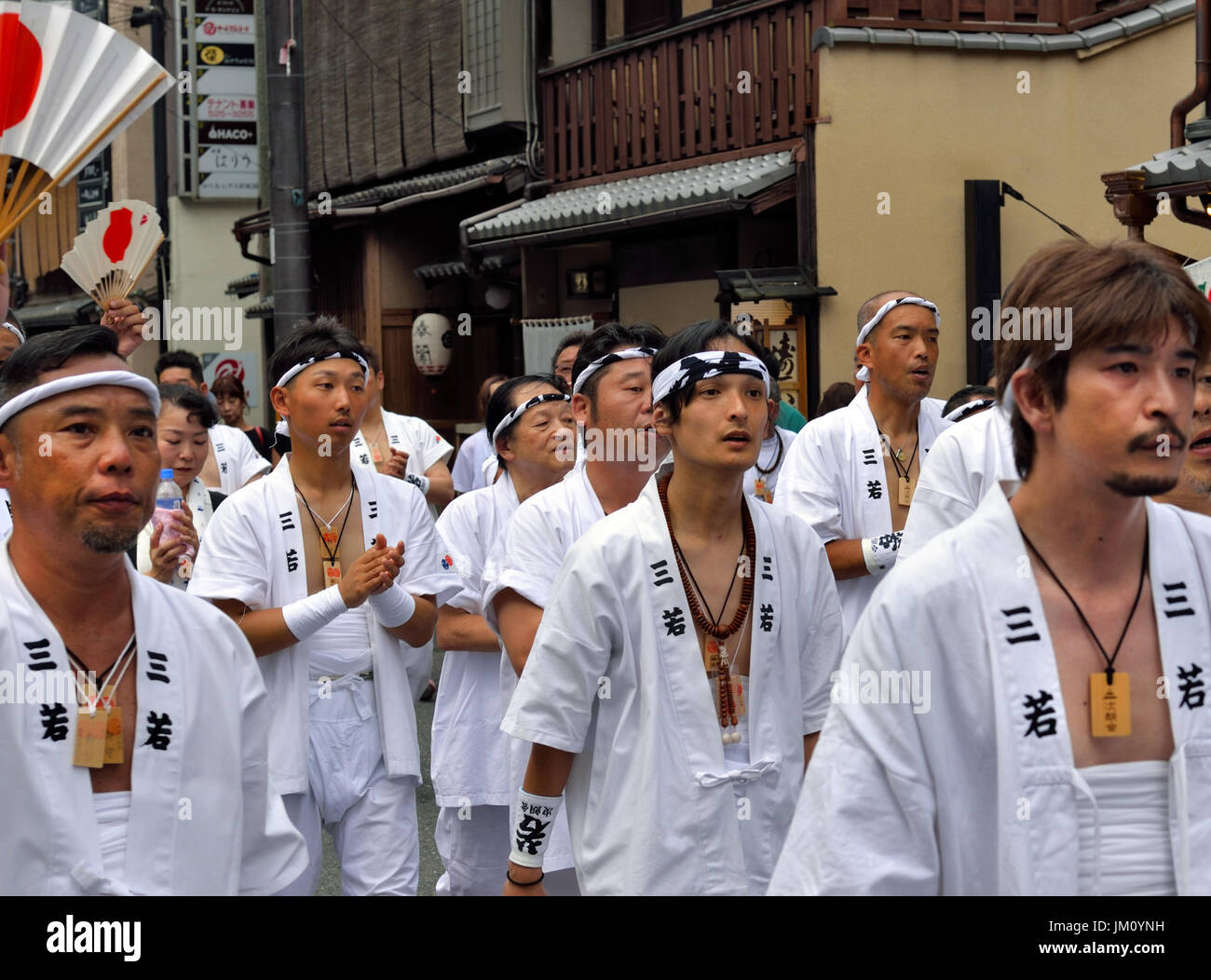 KYOTO, JAPAN - July 24, 2017: A group of men parade down a street in Kyoto, Japan yelling and chanting, as a part of the Gion Festival. Stock Photo