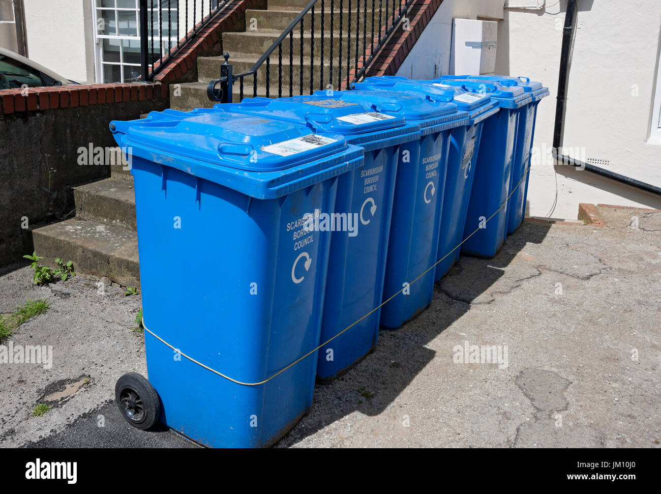 Blue Wheelie bins bin outside flats houses England UK United Kingdom GB