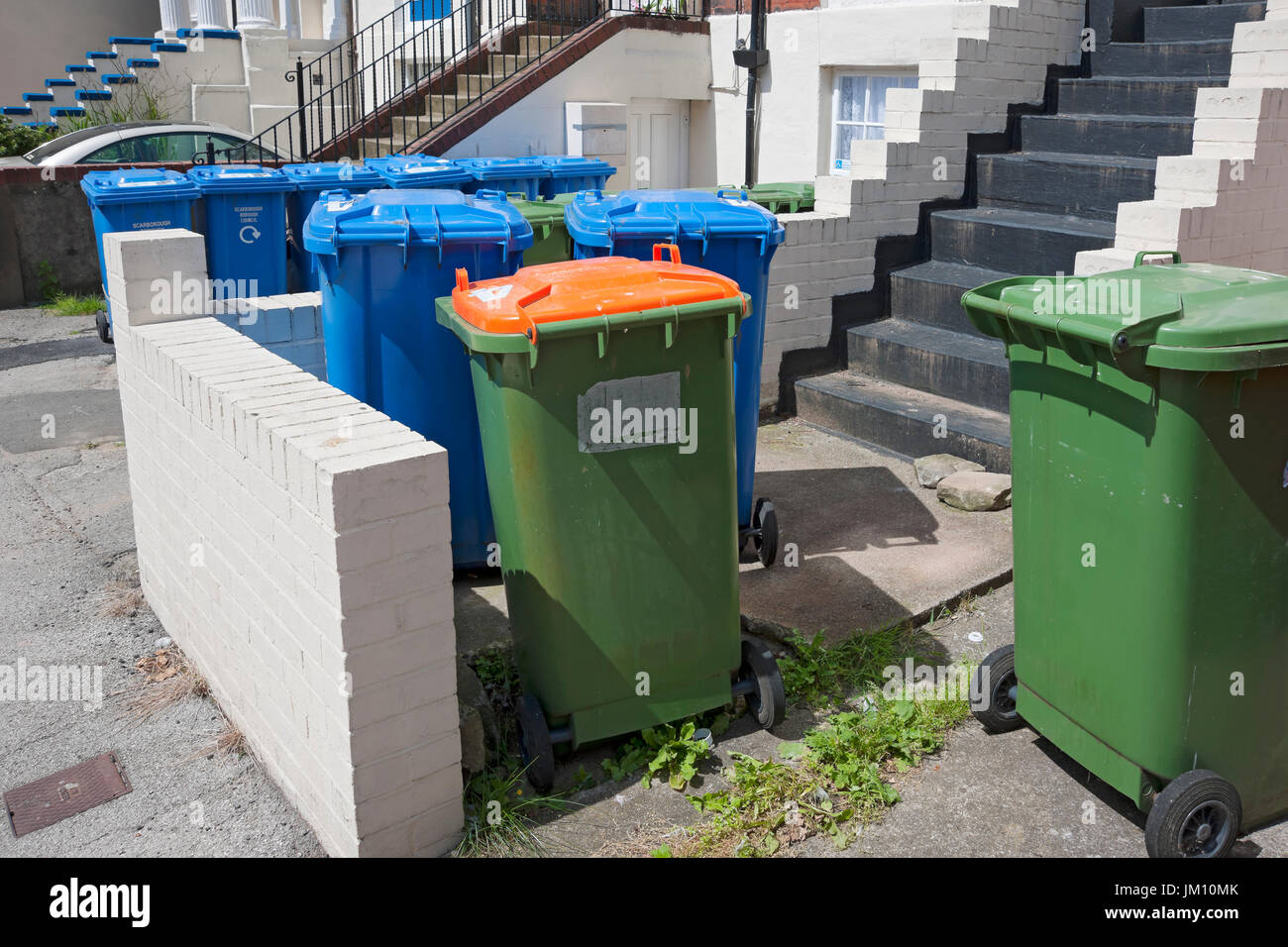 Blue and green wheelie bins bin outside flats houses homes flat house