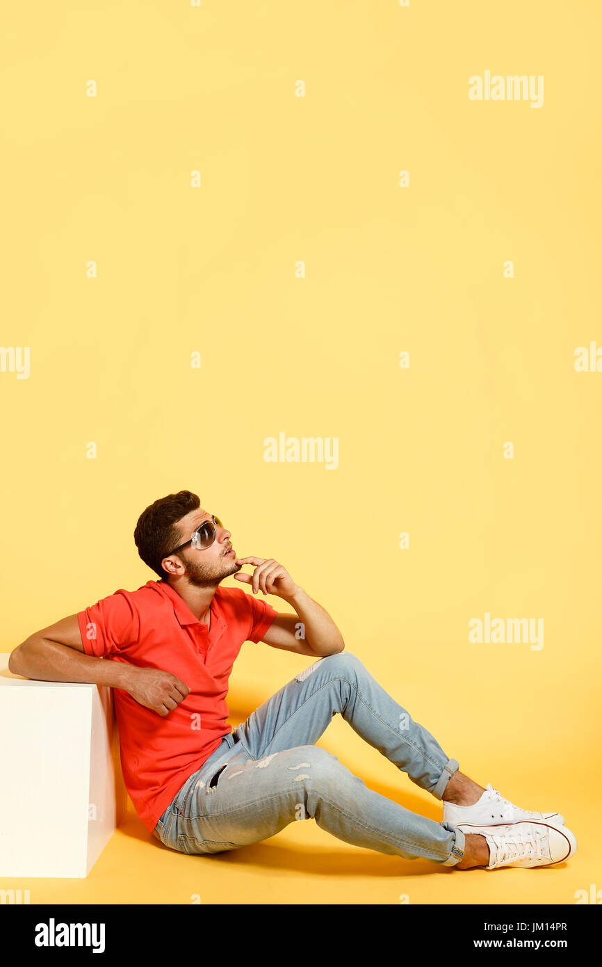 Handsome guy sitting on floor looking up Stock Photo