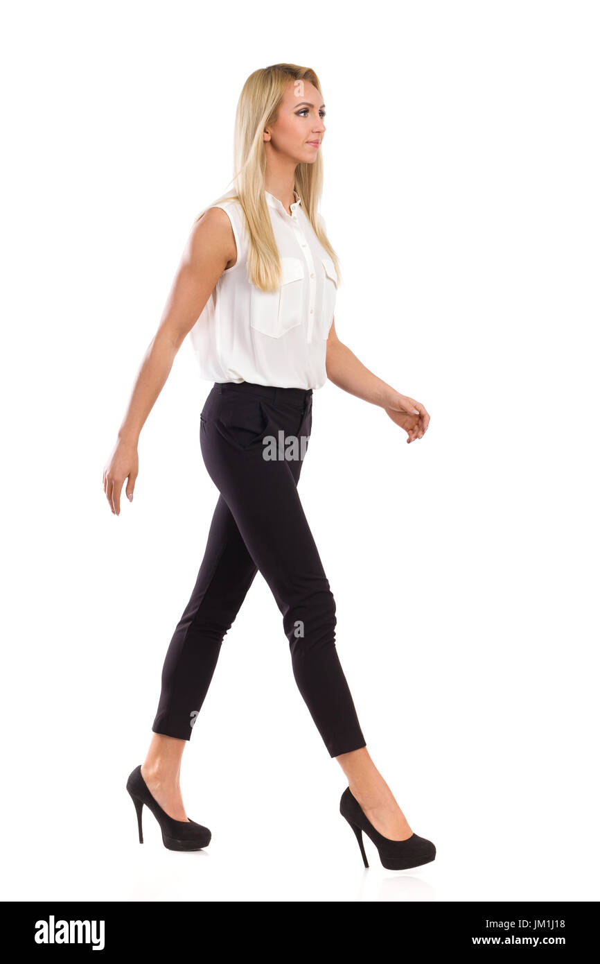 Woman black pants heels walking Cut Out Stock Images & Pictures