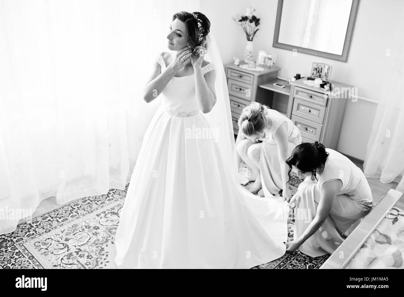 Bridesmaids Helping Gorgeous Bride To Dress Up And Get Ready For