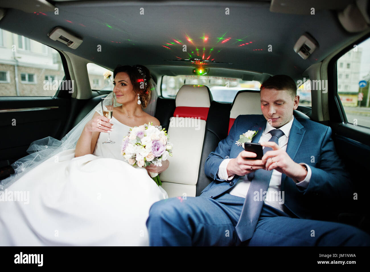 Fantastic wedding couple sitting and and drinking champagne in the