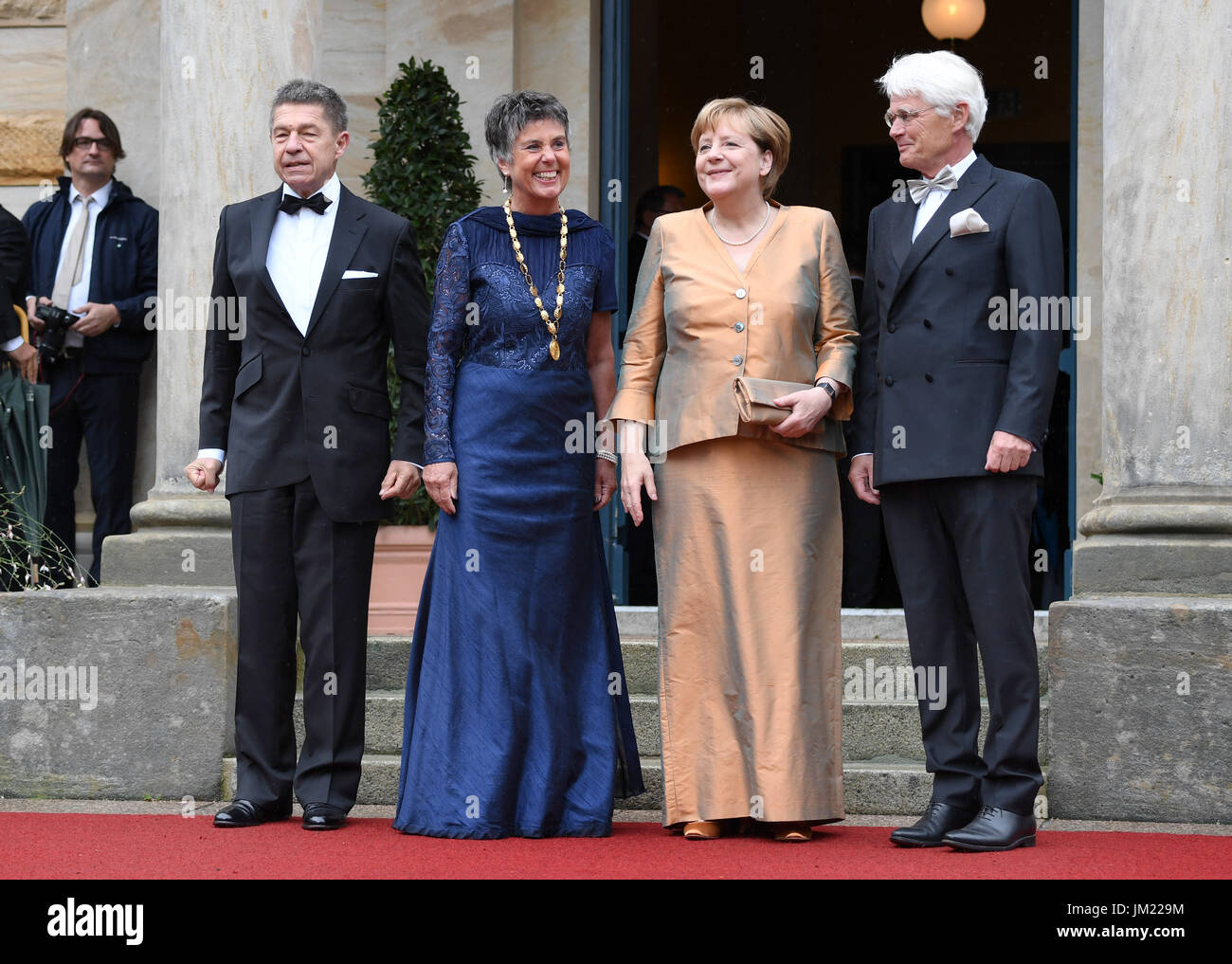 Bayreuth, Germany. 25th July, 2017. German Chancellor Angela Merkel (CDU, 2.f.R), her husband Joachim Sauer (L), mayoress of Bayreuth Brigitte Merk-Erbe (2.f.L), and her husband Thomas (r) arrive at the opening of the Bayreuth Festival 2017 in Bayreuth, Germany, 25 July 2017. The festival opens with the opera 'Die Meistersinger von Nuernberg' (The Master-Singers of Nuremberg). Photo: Tobias Hase/dpa/Alamy Live News Stock Photo