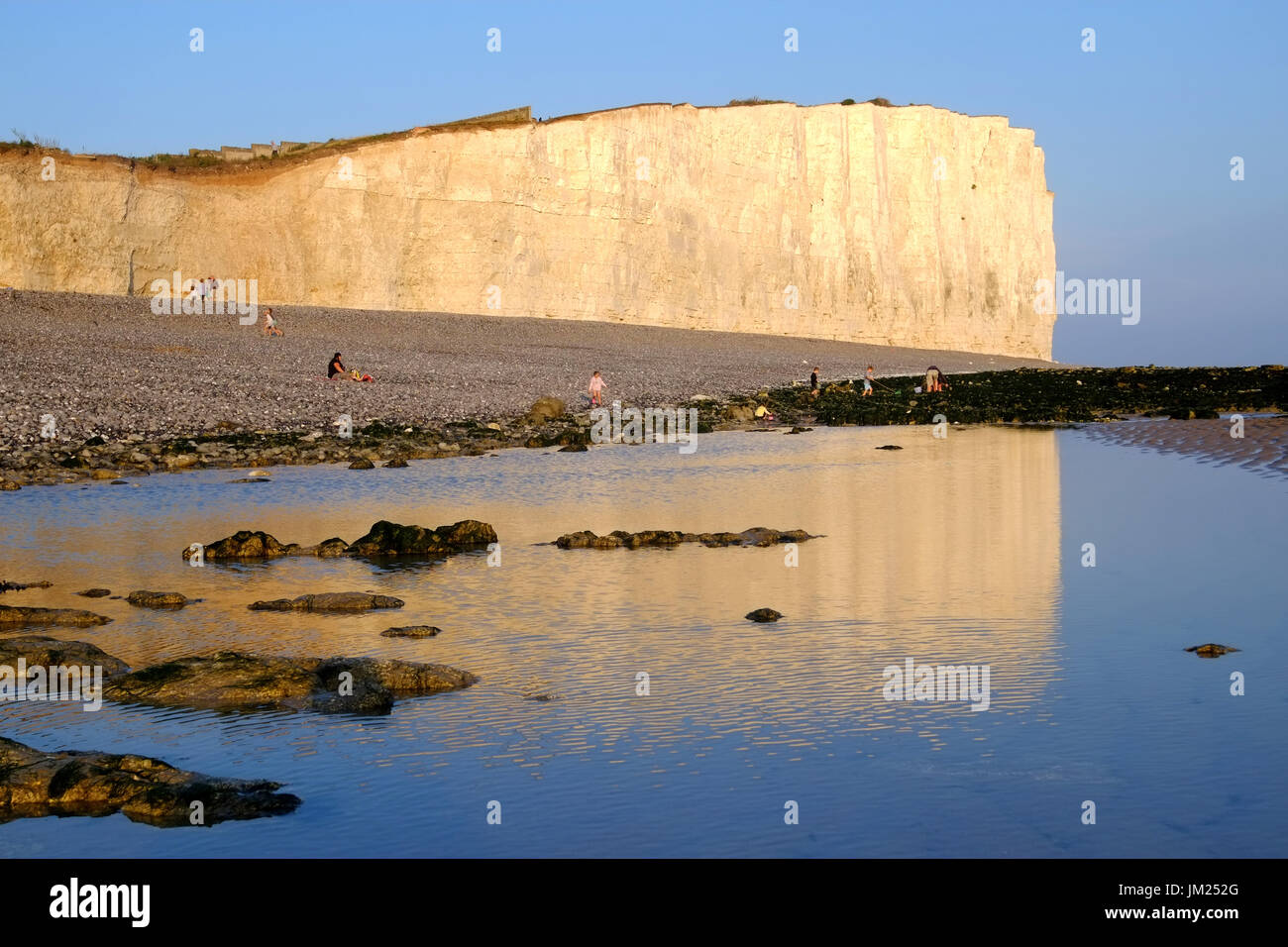Birling Gap, East Sussex. 25th July 2017. People enjoying the last of the sunshie on a beautiful evening in Birling Gap, on the East Sussex coast, before wet weather returns tomorrow. Credit: Peter Cripps/Alamy Live News Stock Photo