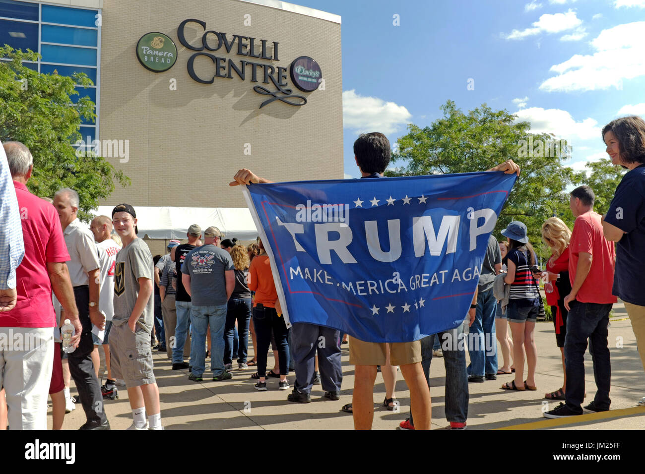 Youngstown, Ohio, USA. 25th July, 2017. Man stands with his Trump 'Make America Great Again' banner while he waits with other Trump supporters to enter the Covelli Centre in Youngstown, Ohio for a political rally on July 25, 2017. Credit: Mark Kanning/Alamy Live News Stock Photo