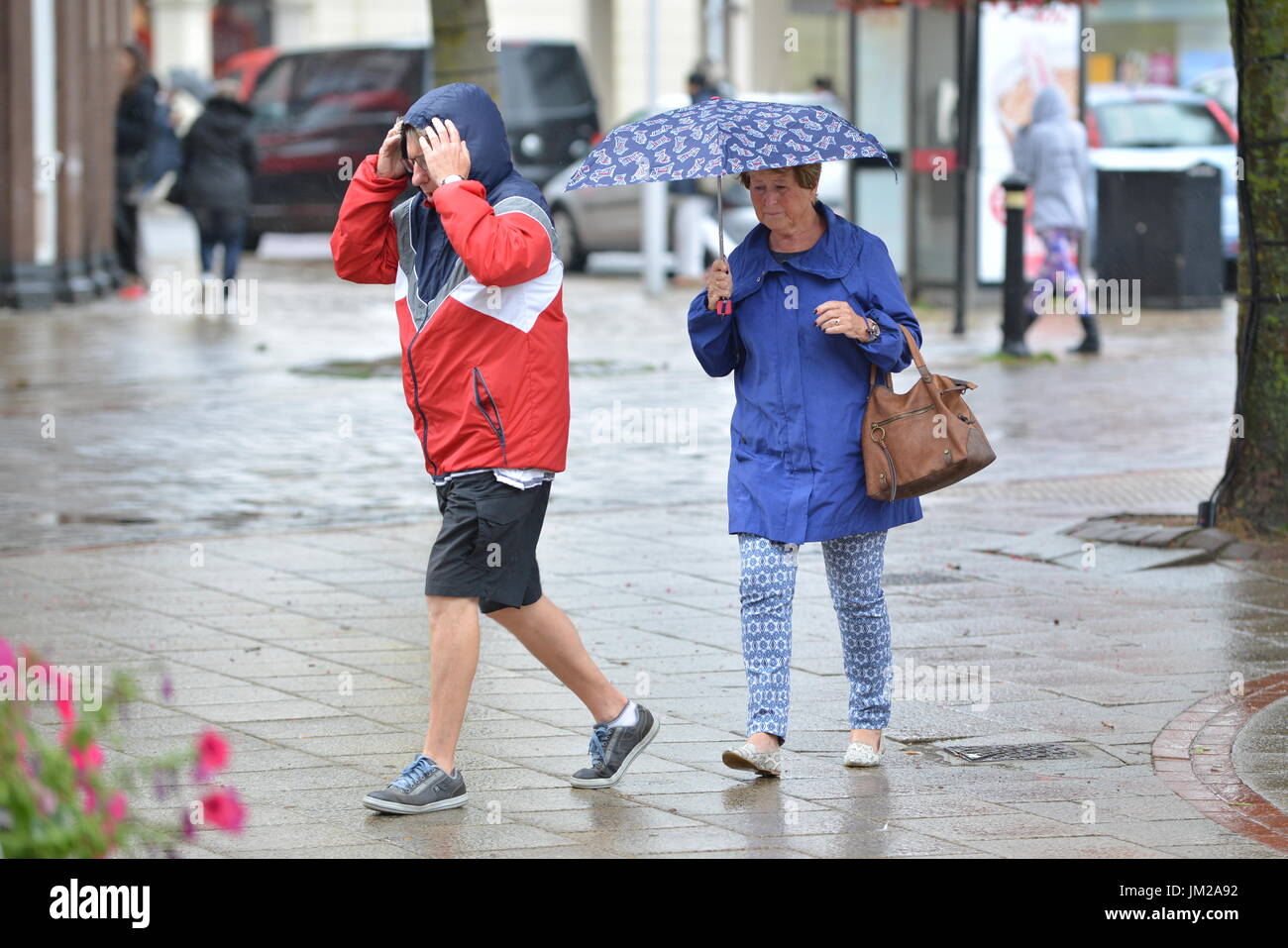 Worthing, West Sussex, England, UK. Wednesday 26th July 2017. People shopping in the rain in Worthing this morning, as the day starts cold and wet, with no sign of letting up in the south of England. Credit: Geoff Smith / Alamy Live News. Stock Photo