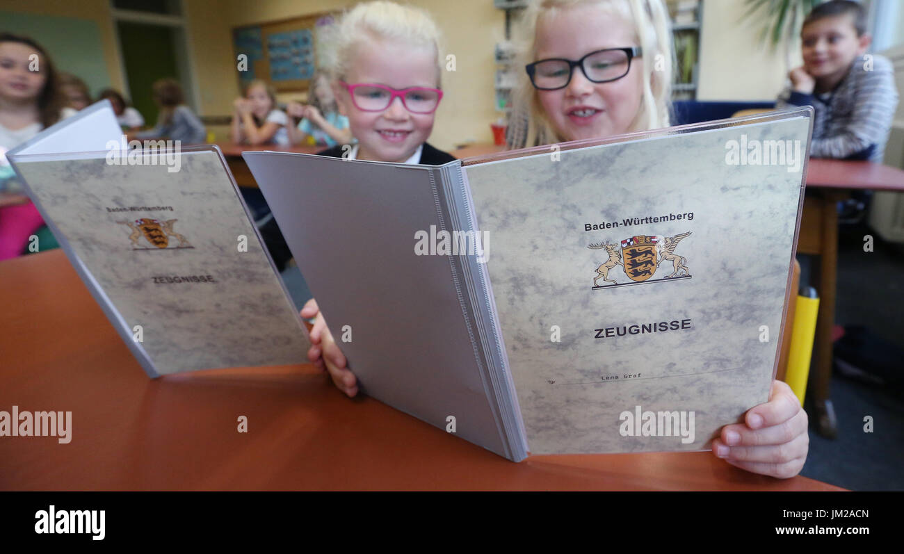 Twins Marie (L) and Lena, 1st grade students at Durmentingen Elementary, compare their certificates in the state of Baden-Württemberg, Germany, 26 July 2017. Students are packing their certificates and finally leaving the classrooms. Summer vacations start for more than 1.5 million students in Baden-Württemberg. Photo: Thomas Warnack/dpa Stock Photo