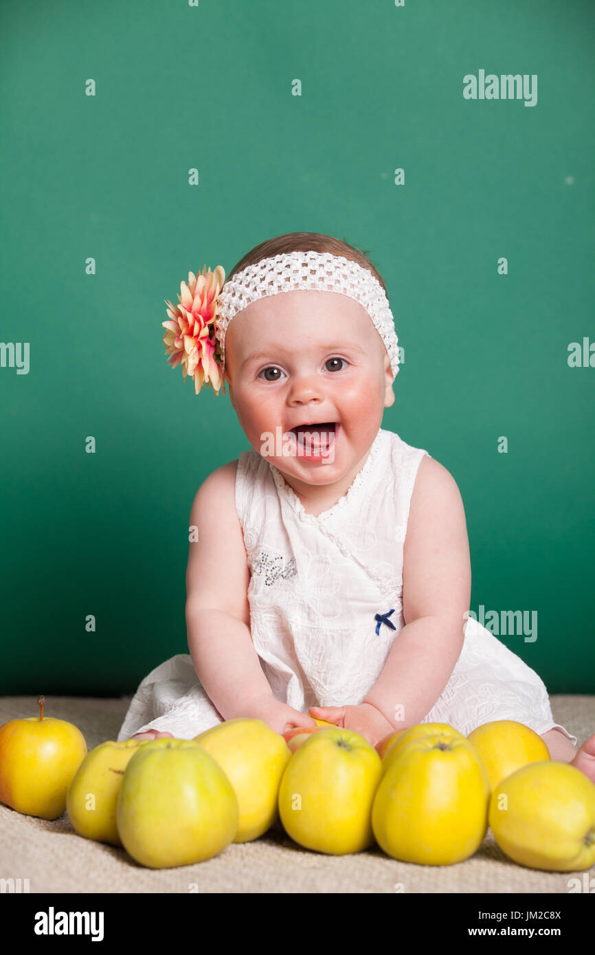 baby girl in a dress with Green apples Stock Photo Alamy
