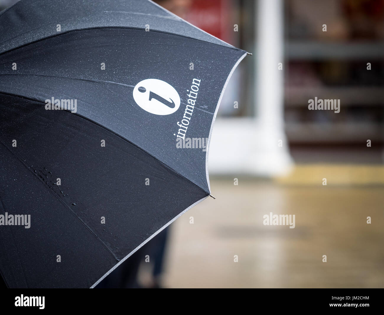 Tourist Information Umbrella in the rain in central Cambridge UK Stock Photo