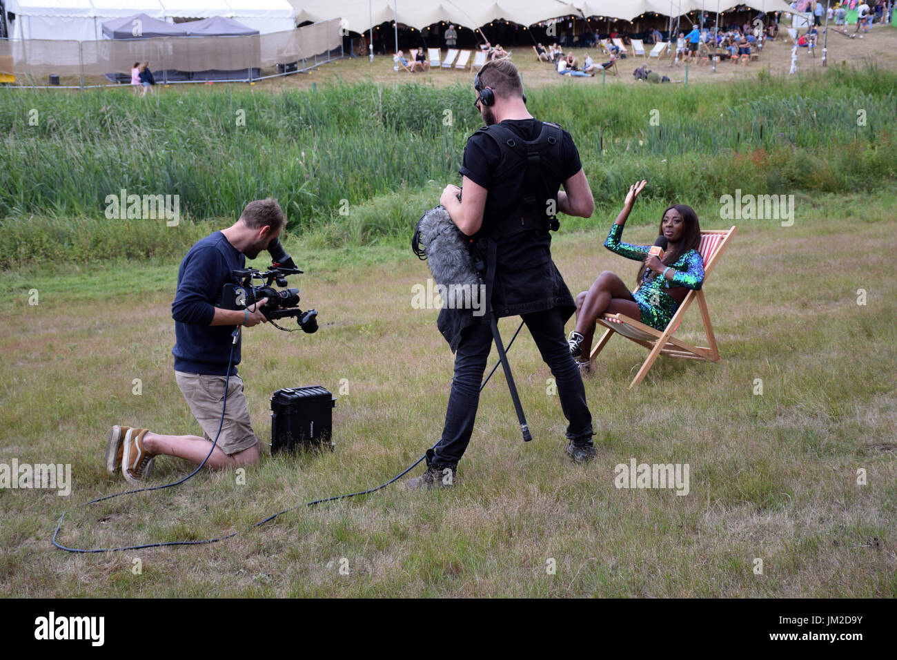 Latitude Festival 2017, Henham Park, Suffolk, UK. TV presenter AJ Odudu doing a piece to camera for E4 Stock Photo