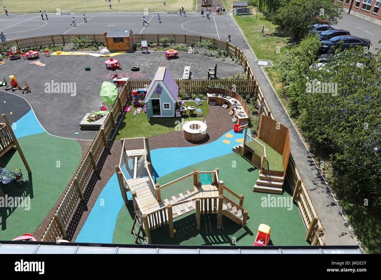 Outside play area at a new primary school in London UK. Shows elevated climbing equipment, play house and coloured surfaces. Stock Photo