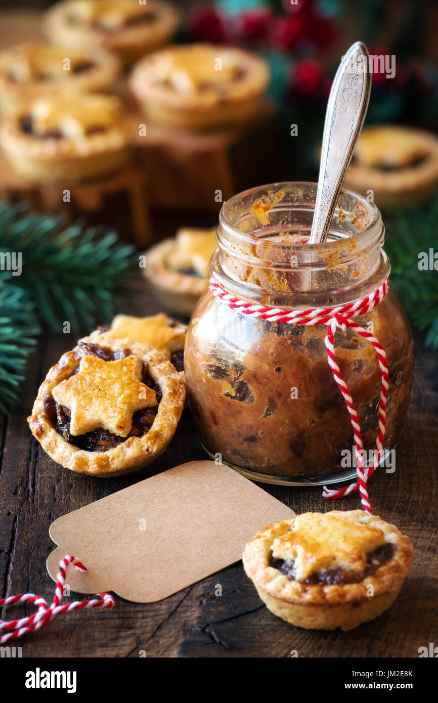 Traditional festive Christmas mince pies with a jar of homemade mincemeat and an empty tag Stock