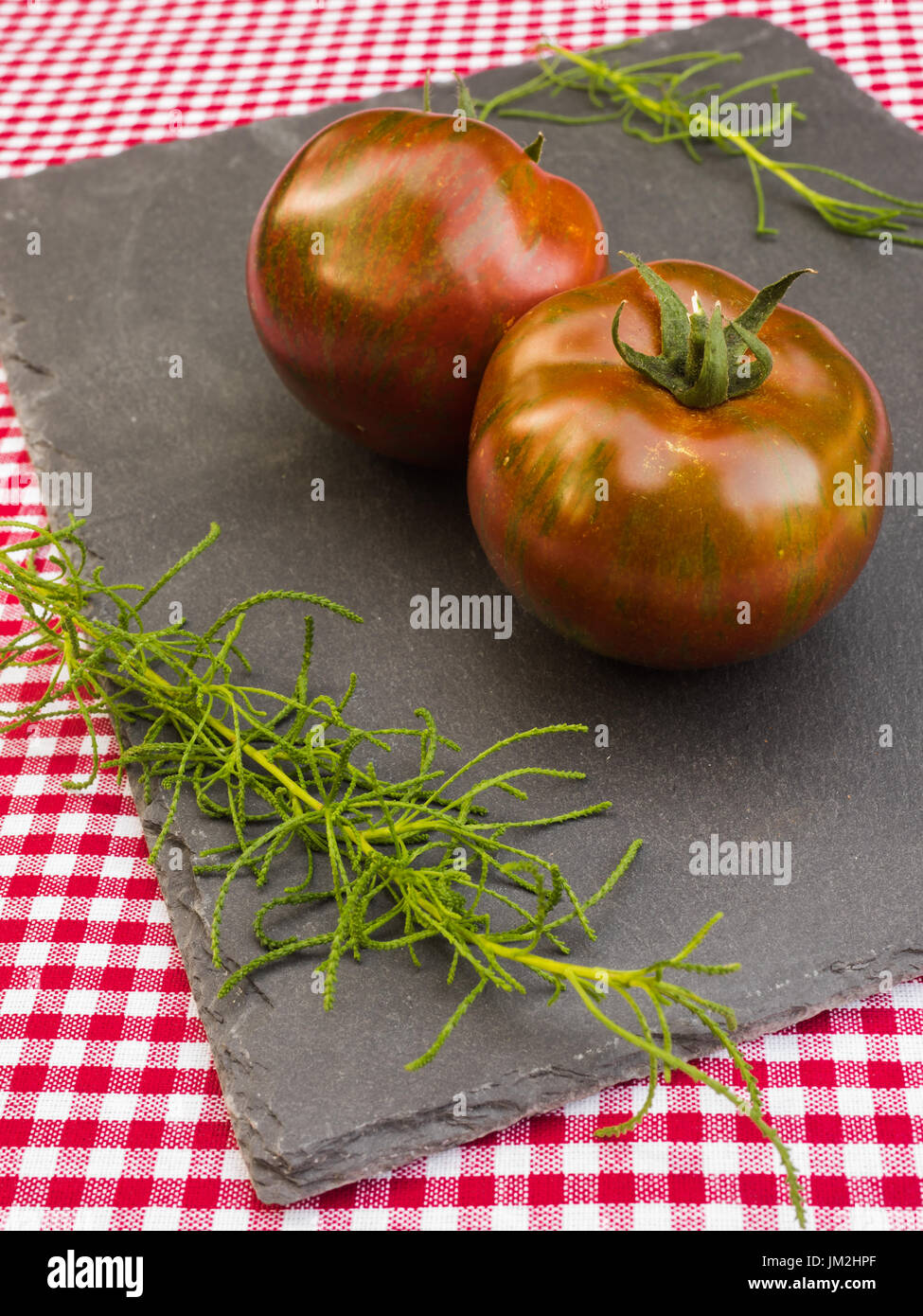 Tomatoes and herbs on a slate Stock Photo
