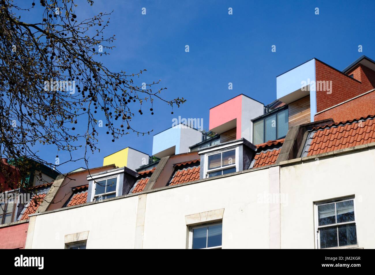 Abstract view of rooftops of Victorian or Edwardian terraced houses juxtaposed with modern terraced housing rising above from behind Stock Photo