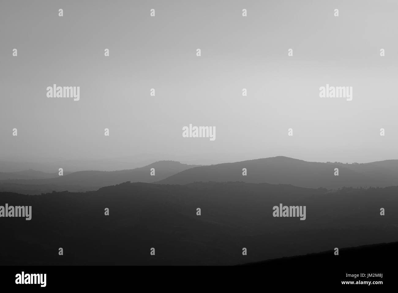 Silhouette layers of hills at sunset with fog. Black and white photo. Stock Photo