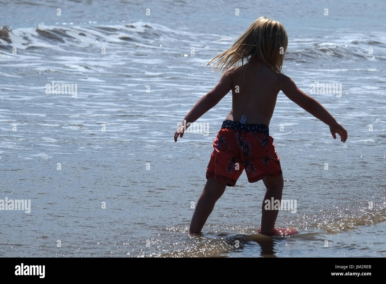 Young girl playing in the shallow sea at low tide. Stock Photo