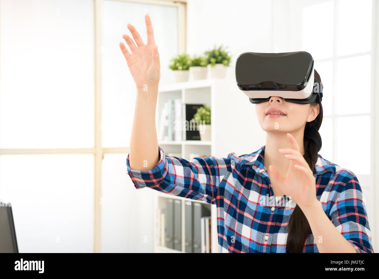 close up of smile happy woman getting using VR-headset glasses of virtual reality at home and showing much gesticulating hands as organize image on th Stock Photo