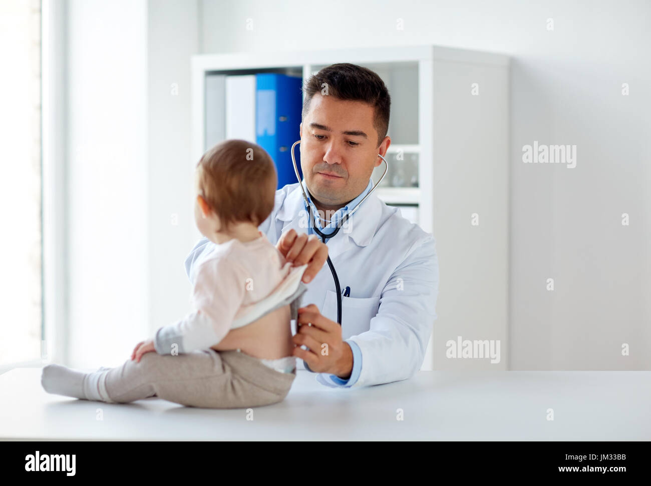 doctor with stethoscope listening baby at clinic Stock Photo - Alamy