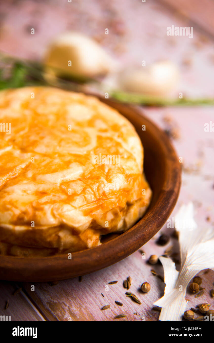 closeup of an earthenware plate with a typical tortilla de patatas, spanish omelet, on a rustic wooden table Stock Photo