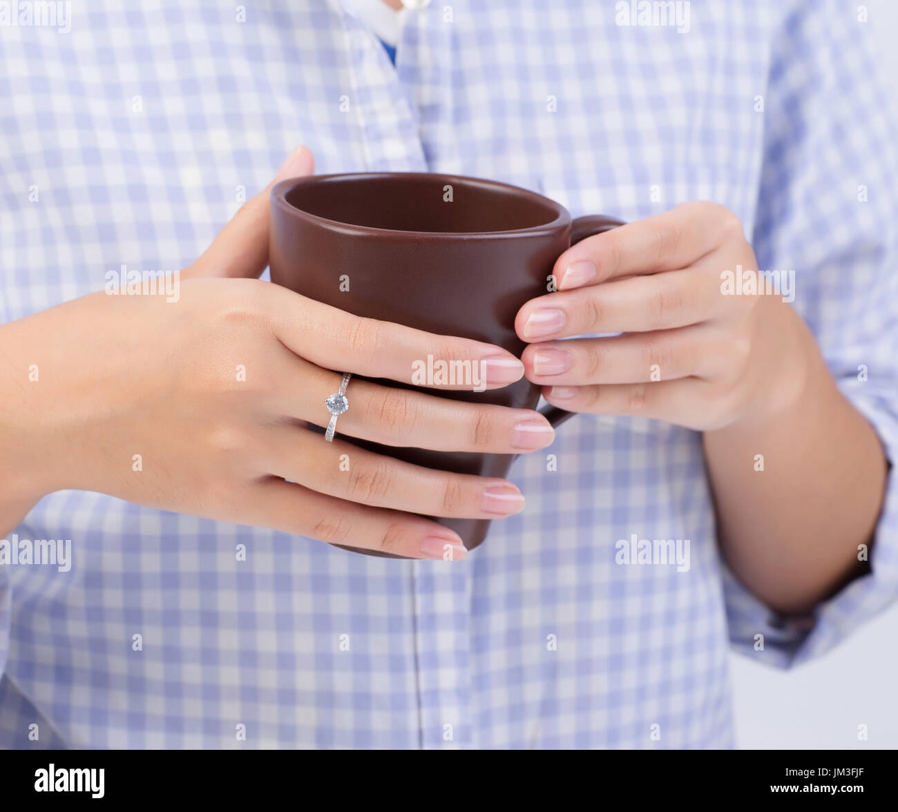 Female hands holding a brown cup of coffee Stock Photo