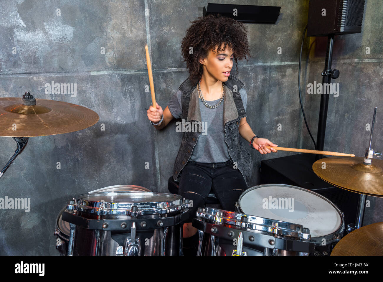 young woman playing drums in musical studio, drummer rock concept Stock Photo