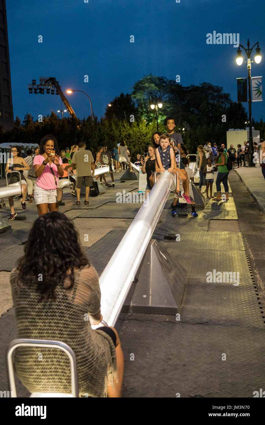 Detroit, Michigan - People ride large illuminated seesaws at the opening of Beacon Park, a privately-financed public space developed by DTE Energy. Th Stock Photo