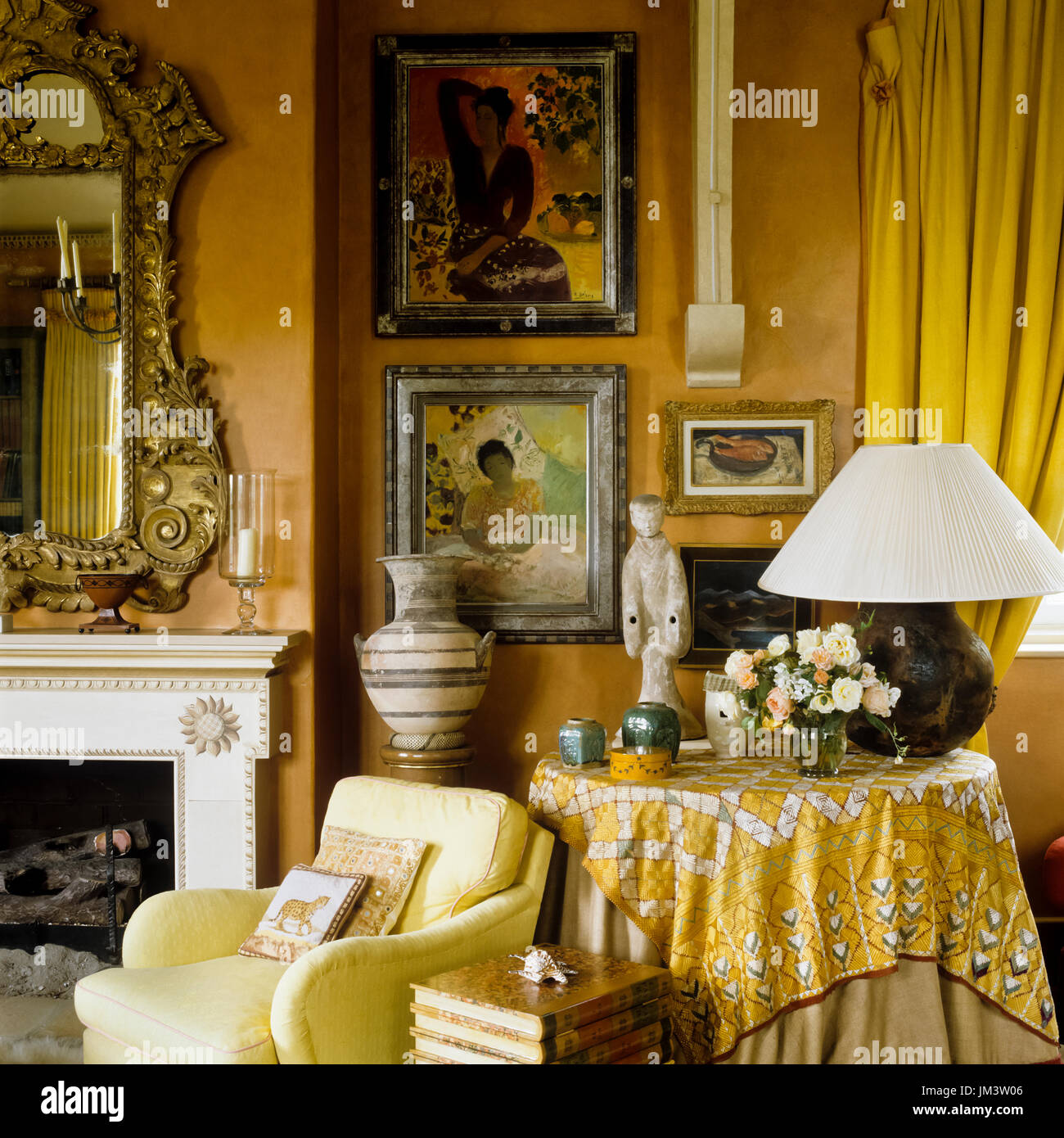 Yellow toned living room with paintings Stock Photo - Alamy