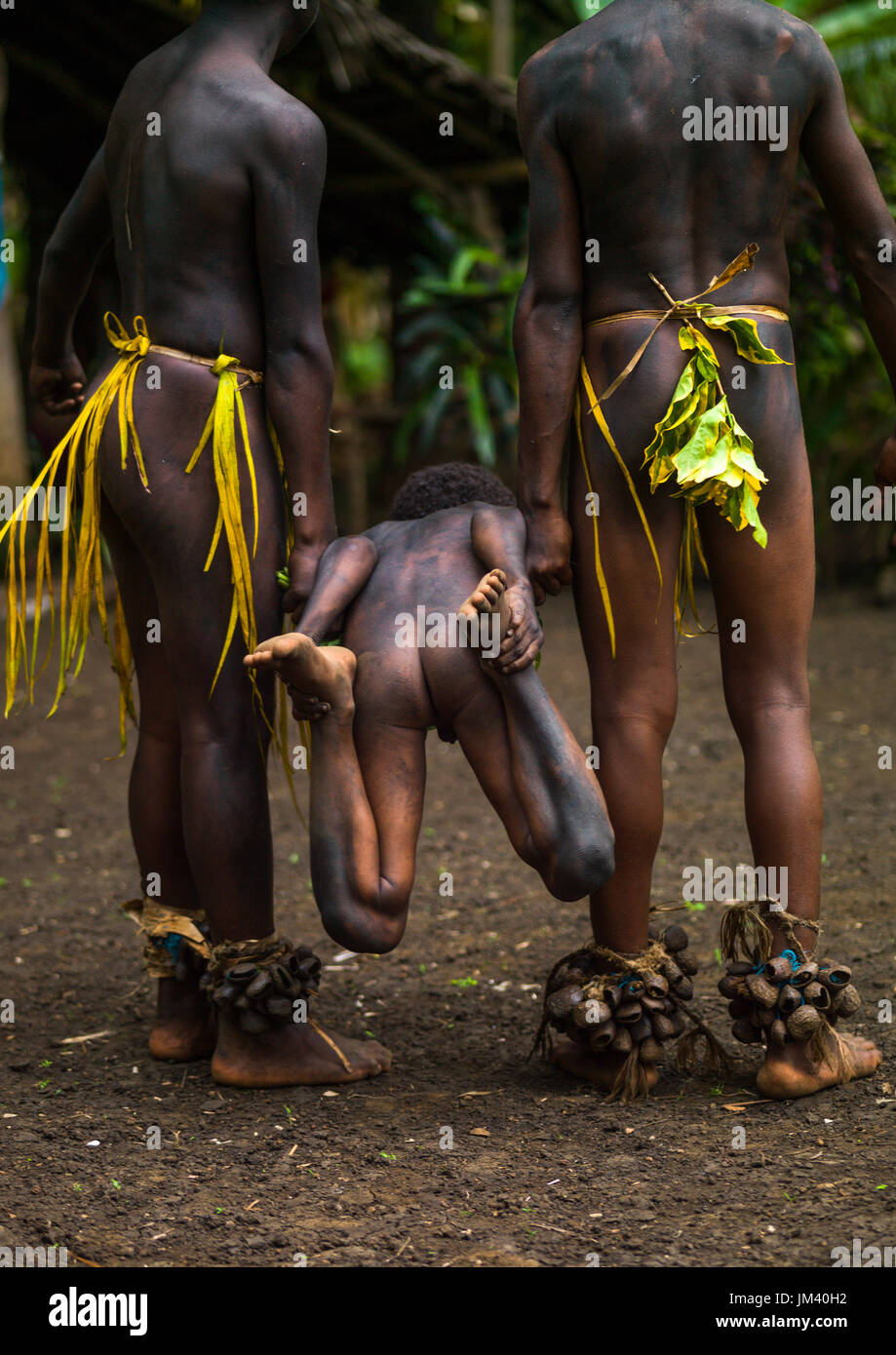 Small Nambas tribesmen demonstrating with a child a traditional stretcher made from leaves, Malekula island, Gortiengser, Vanuatu Stock Photo