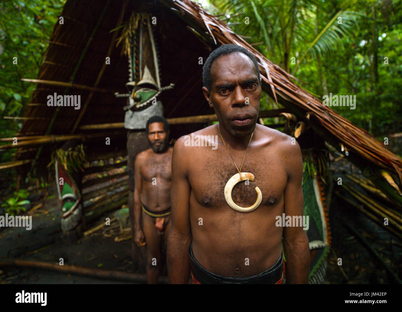 Portrait of chieftain Sekor and his father in front of a painted grade statue, Ambrym island, Olal, Vanuatu Stock Photo