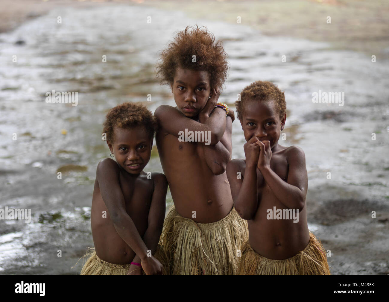 Three girls in traditional grass skirts, Tanna island, Yakel, Vanuatu Stock Photo