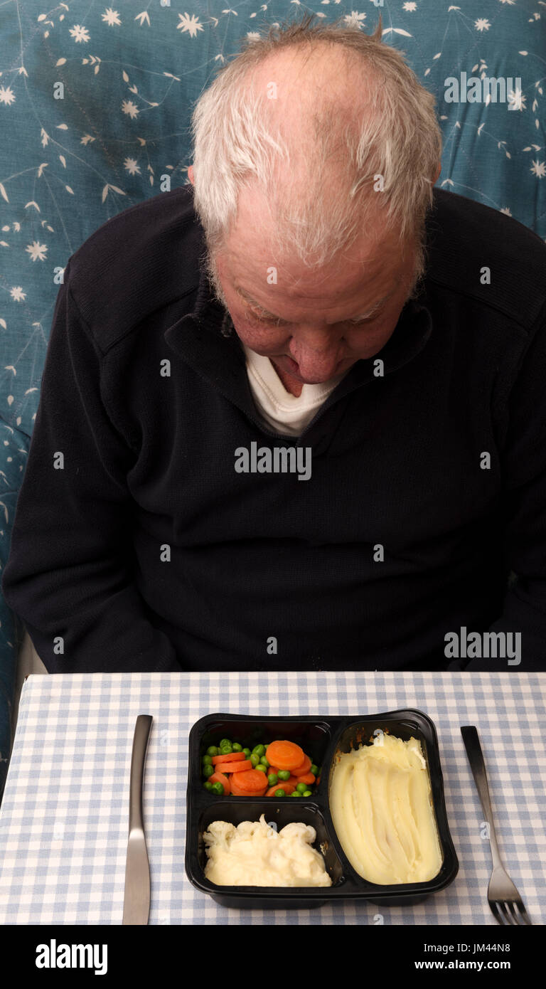 Elderly man looking down at his microwave ready meal Stock Photo