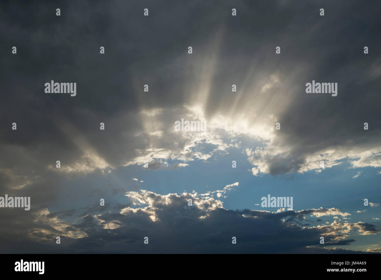 Clouds with sun rays shining through after a late afternoon rain storm. Stock Photo
