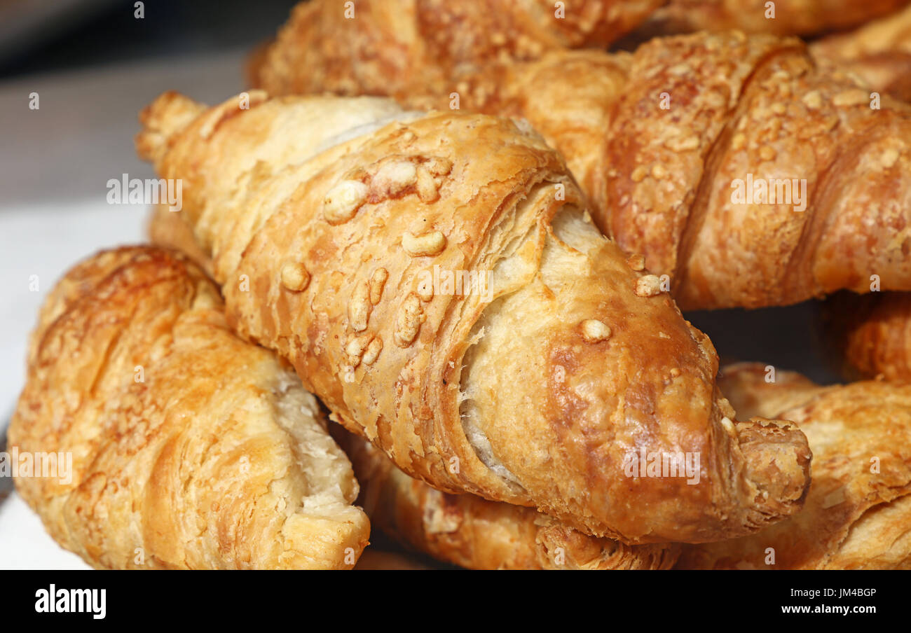 Freshly baked golden brown French croissants with cheese topping in