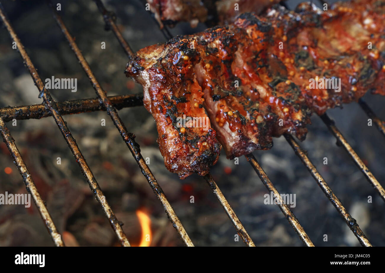 Rack of pork spare ribs cooked on fire barbecue grill, close up, high