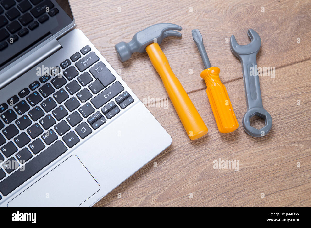 Concept of repair and maintenance on a laptop computer with a small hammer,  screwdriver and spanner alongside the open notebook on a desk Stock Photo -  Alamy