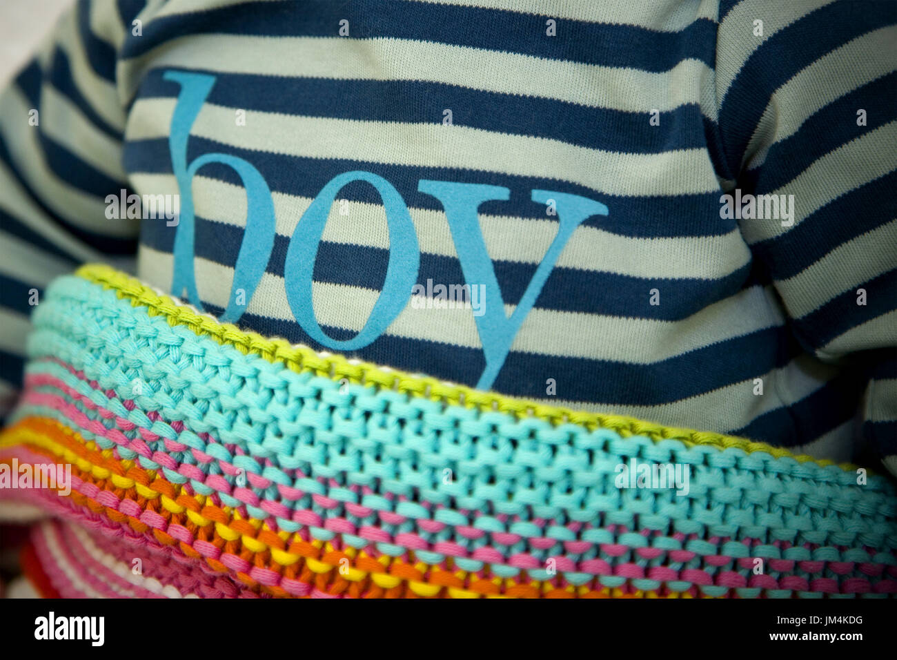 Cute Baby Boy with boy written on his baby grow, covered with a lovely