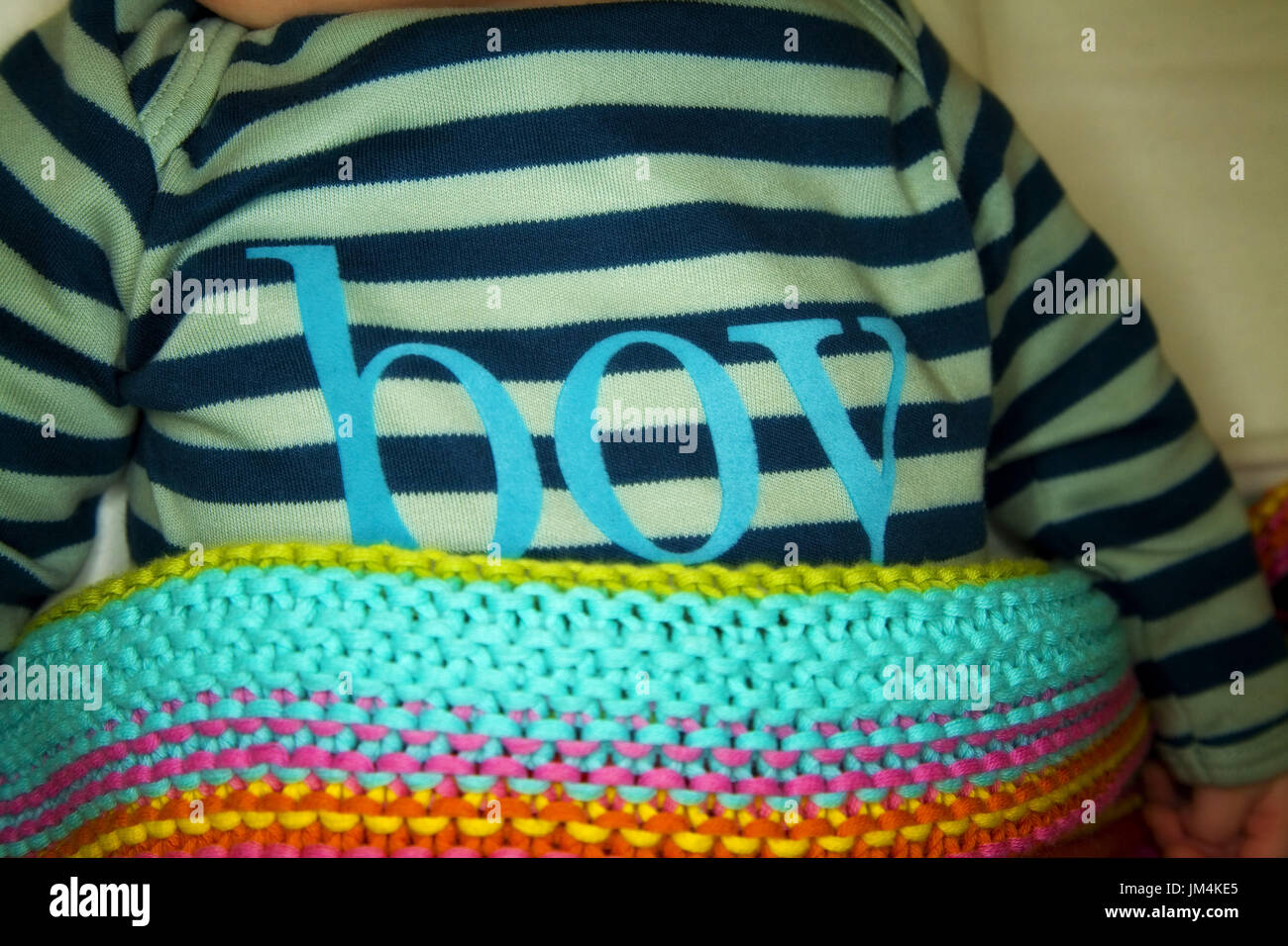 Cute Baby Boy with boy written on his baby grow, covered with a lovely