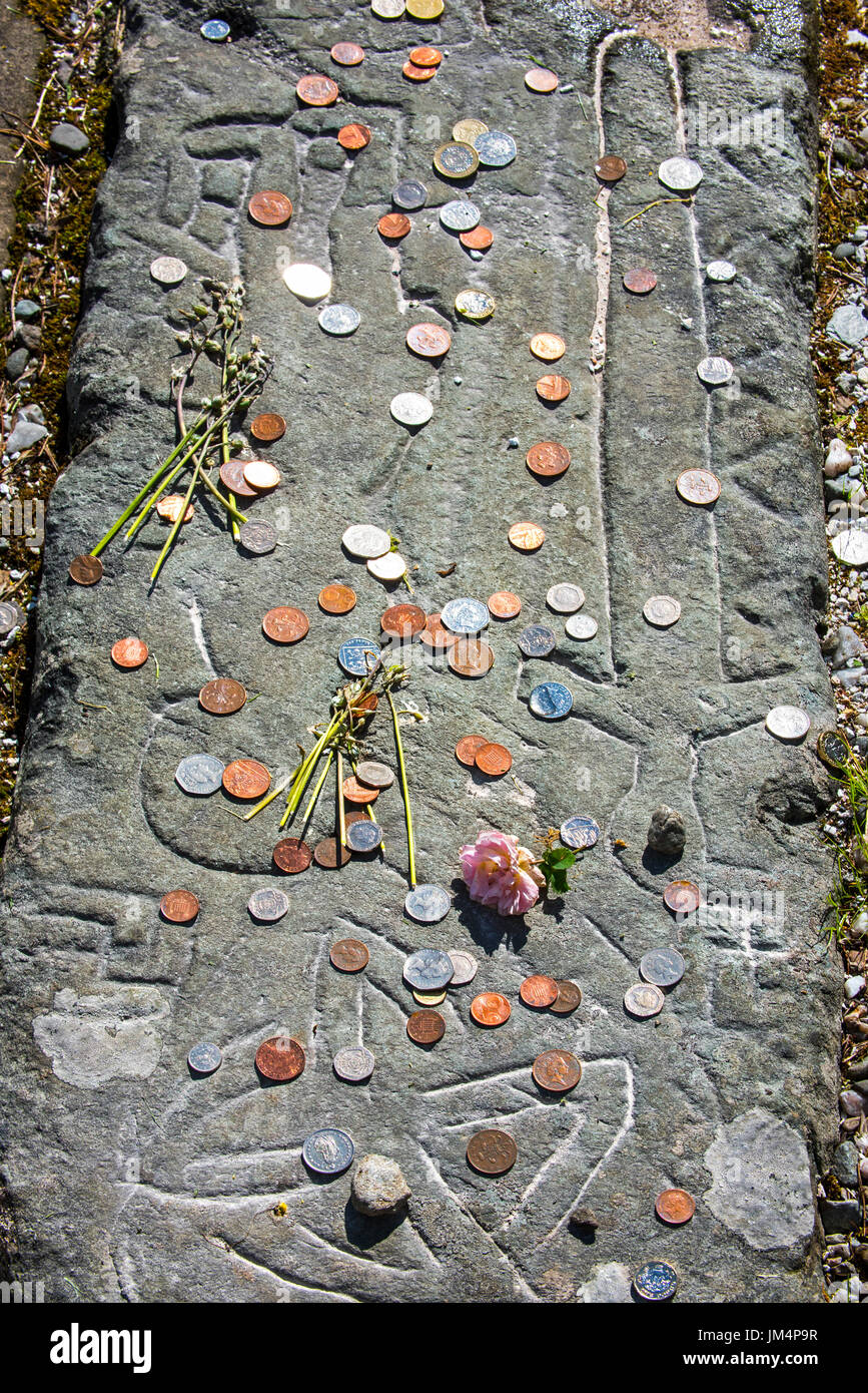 Coins on tombstone marking the grave of Rob Roy MacGregor at the Balquhidder kirkyard, Stirling, Scotland, UK Stock Photo