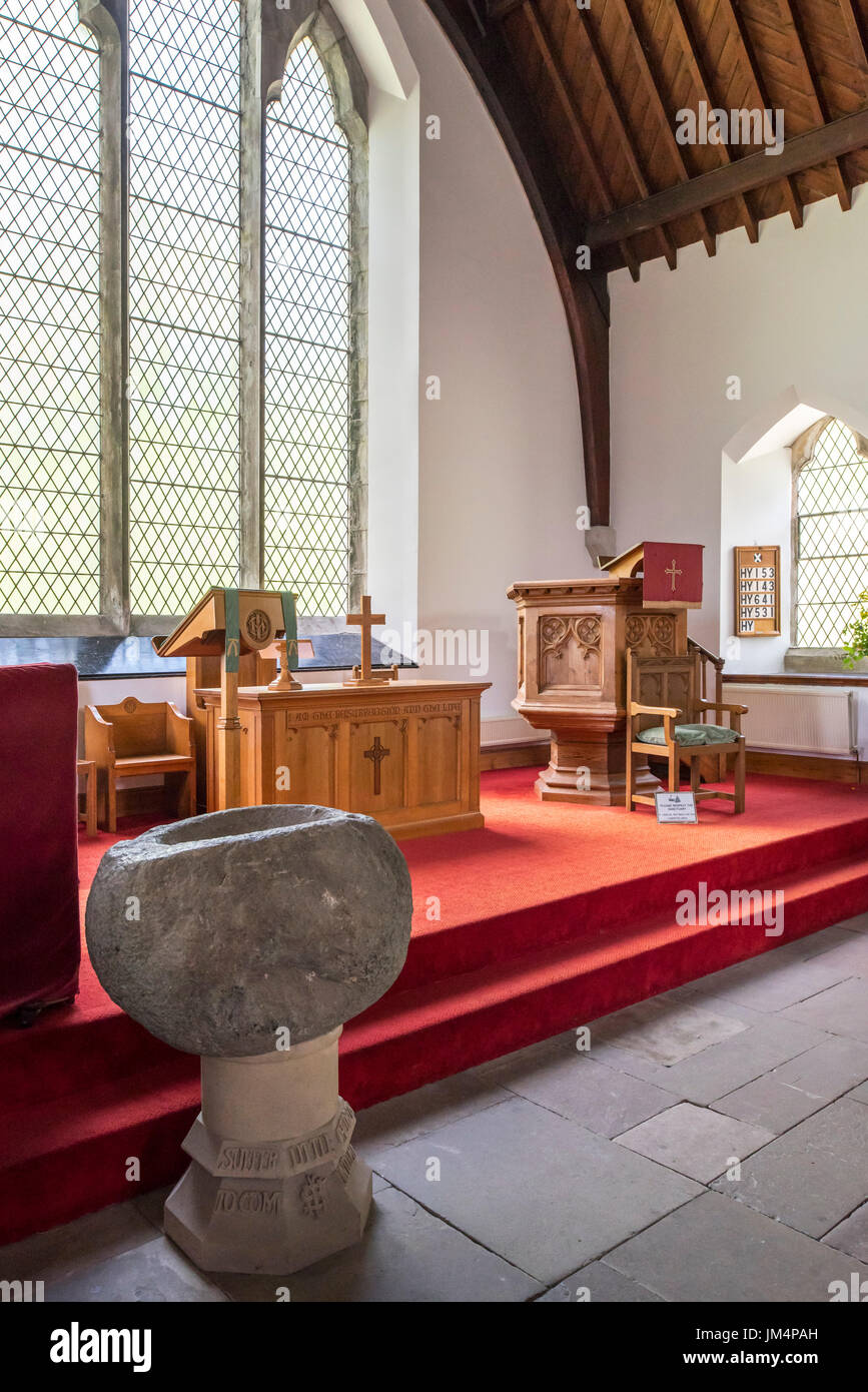 Interior showing stone baptismal font, altar and wooden pulpit of the Balquhidder Parish Church, Stirling, Scotland, UK Stock Photo