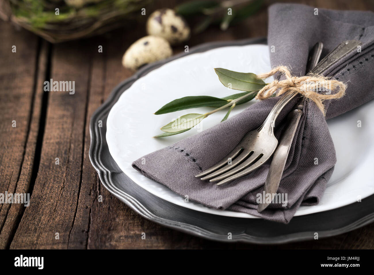 Easter table setting with vintage silverware with an olive branch on ... Easter table setting with vintage silverware with an olive branch on ...
