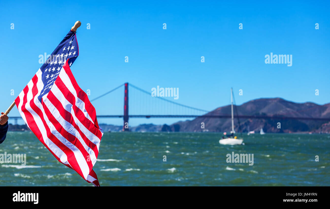 SAN FRANCISCO-SEPT 25: American flag waving with the Golden Gate Bridge in the background on the day of USA's historic win of the America's Cup title  Stock Photo