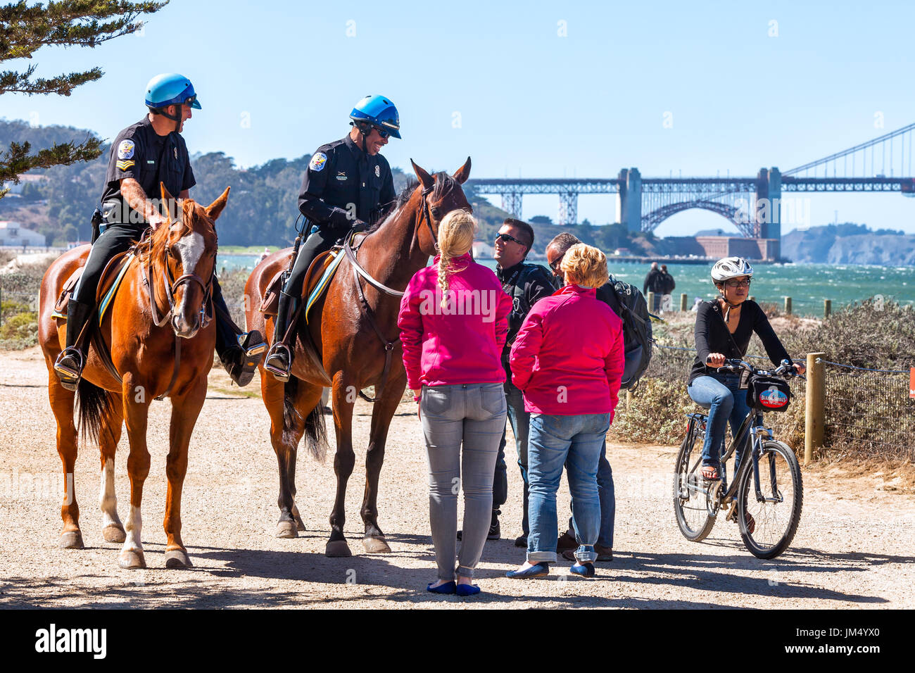 SAN FRANCISCO-SEPT 25, 2013: US Park Police officers greet visitors at the Crissy Field waterfront. Golden Gate Bridge in the background. Stock Photo