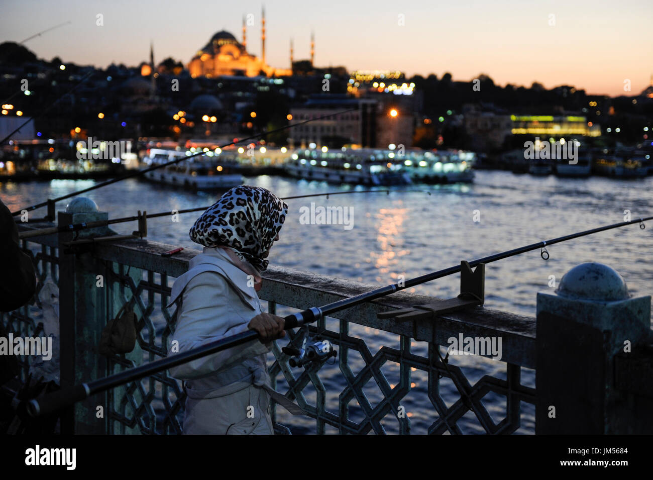 TURKEY Istanbul , Golden Horn, woman with headscarf fishing at Galata bridge / TUERKEI Istanbul, Frau mit Kopftuch angelt an der Galata Bruecke Stock Photo
