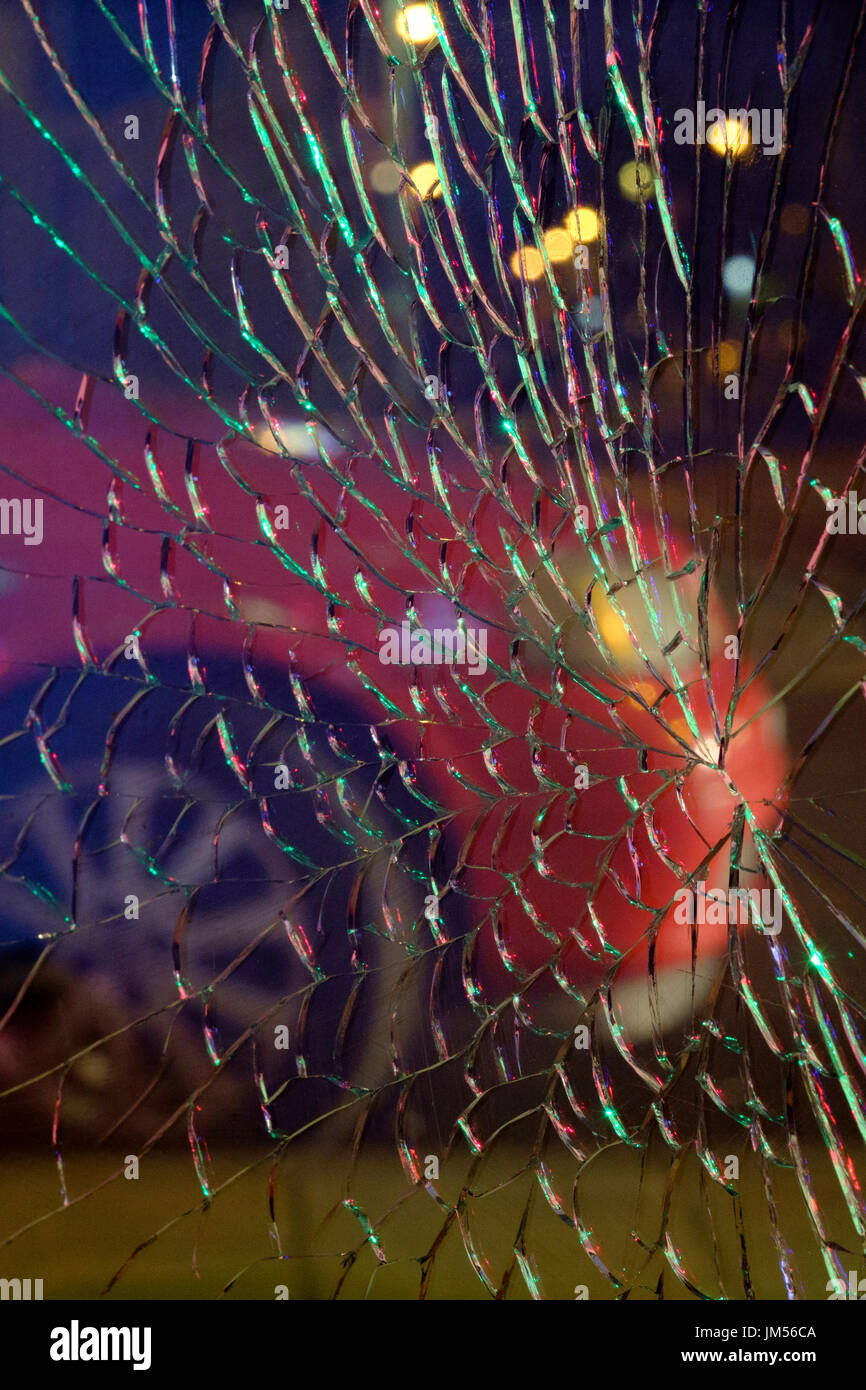 car parked in road at night viewed through a shattered glass window england uk Stock Photo
