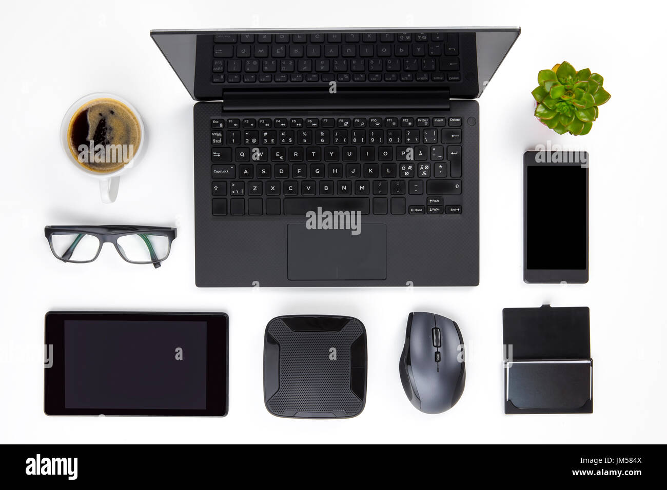 Various Devices Arranged On White Office Desk Stock Photo