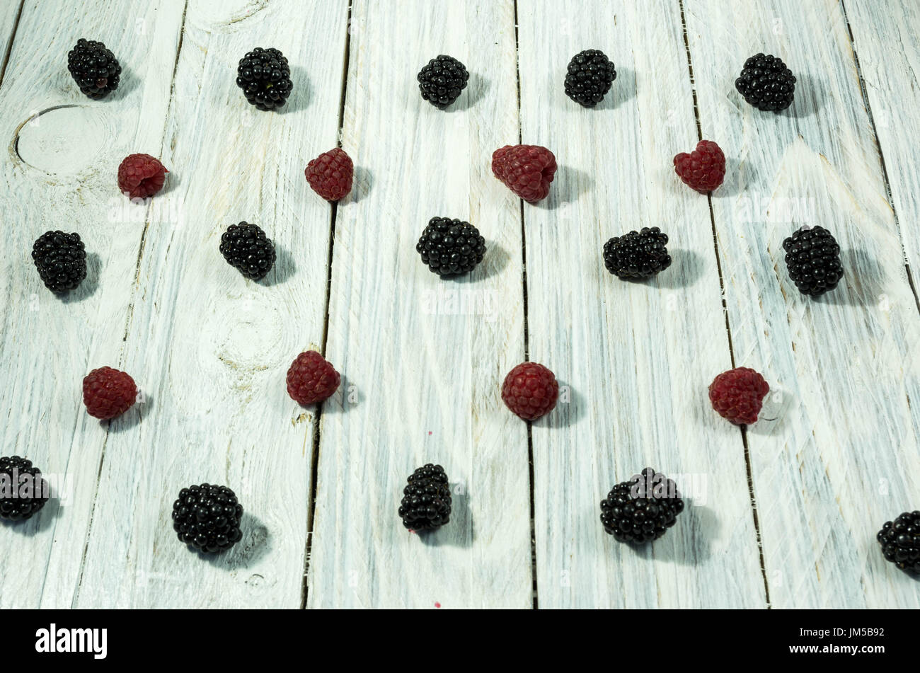 Blackberry and raspberries. are arranged in a row. Top view. Berries on