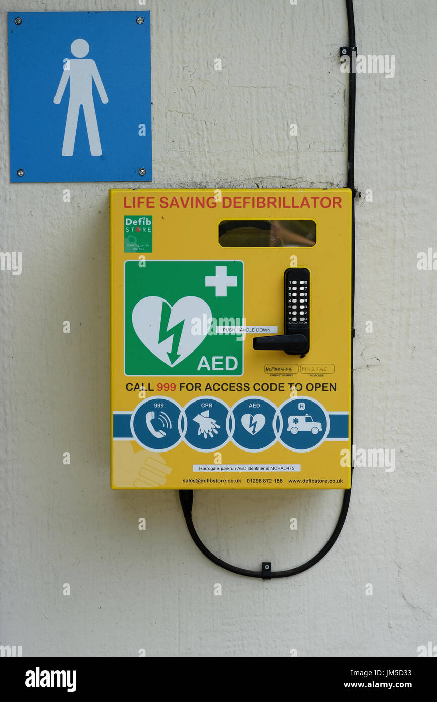 Defibrillator mounted on the wall of a male public connvenience toilet in Harrogate, North Yorkshire, England, UK. Stock Photo