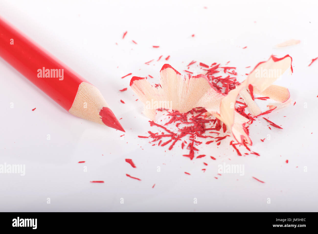 Sharpened red pencil with shavings on white background, viewed from above Stock Photo