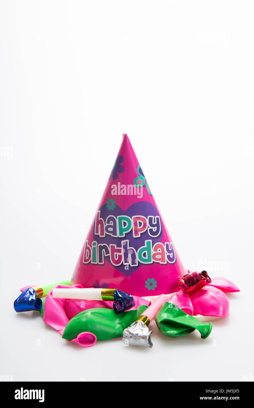 Pink party hat with balloons and party blower Stock Photo - Alamy